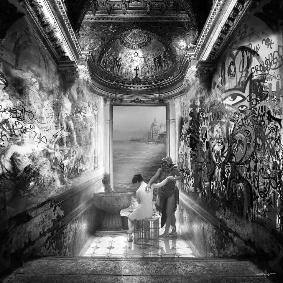 Une femme nue assise sur une cage est lustrée par une autre femme drapée. La scène se déroule dans un ancien bâtiment couvert de graffitis, avec une vue sur la mer et une ville au loin.
